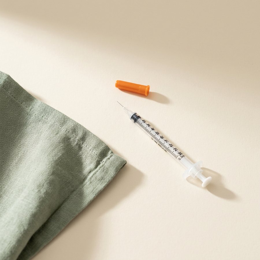 Small insulin syringe on linen